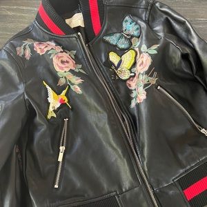 Silence and noise faux leather with hand painted florals and added patches.